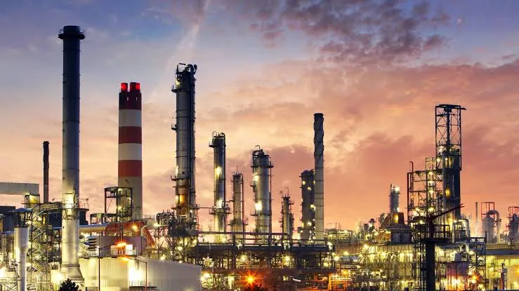 Industrial processing plant with towers and stacks at dusk