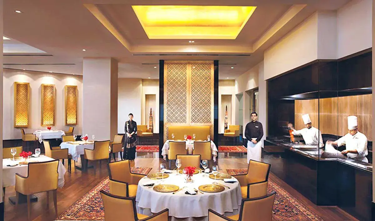 Fine-dining restaurant interior with set tables and an open kitchen
